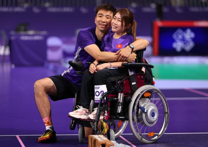 A male ramp operator hugs a female boccia athlete